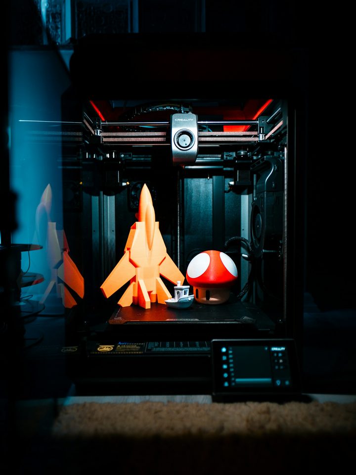 Creality K1 enclosed 3D printer with orange prints inside